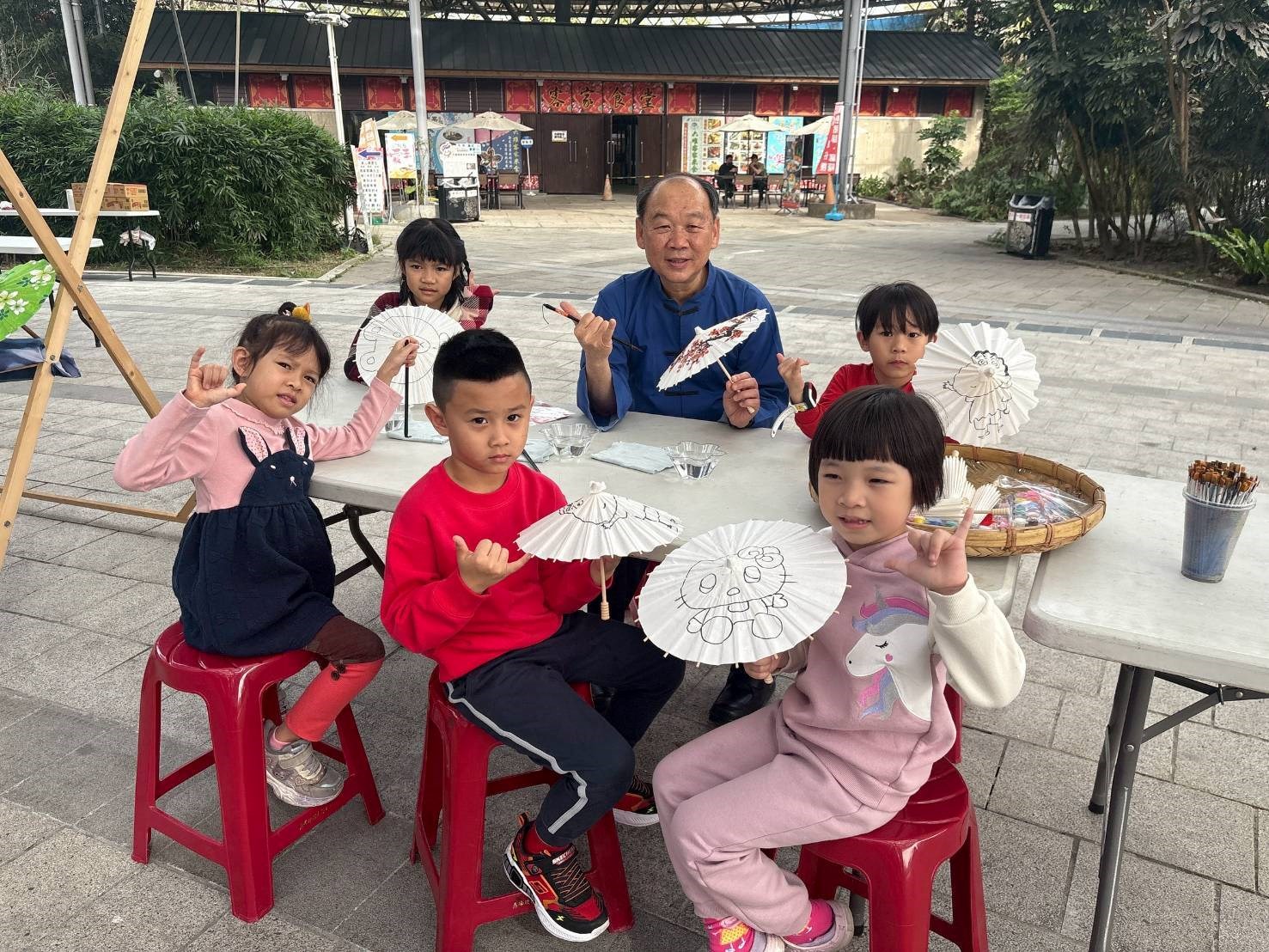 客發中心謝勝信主任與小朋友彩繪紙傘