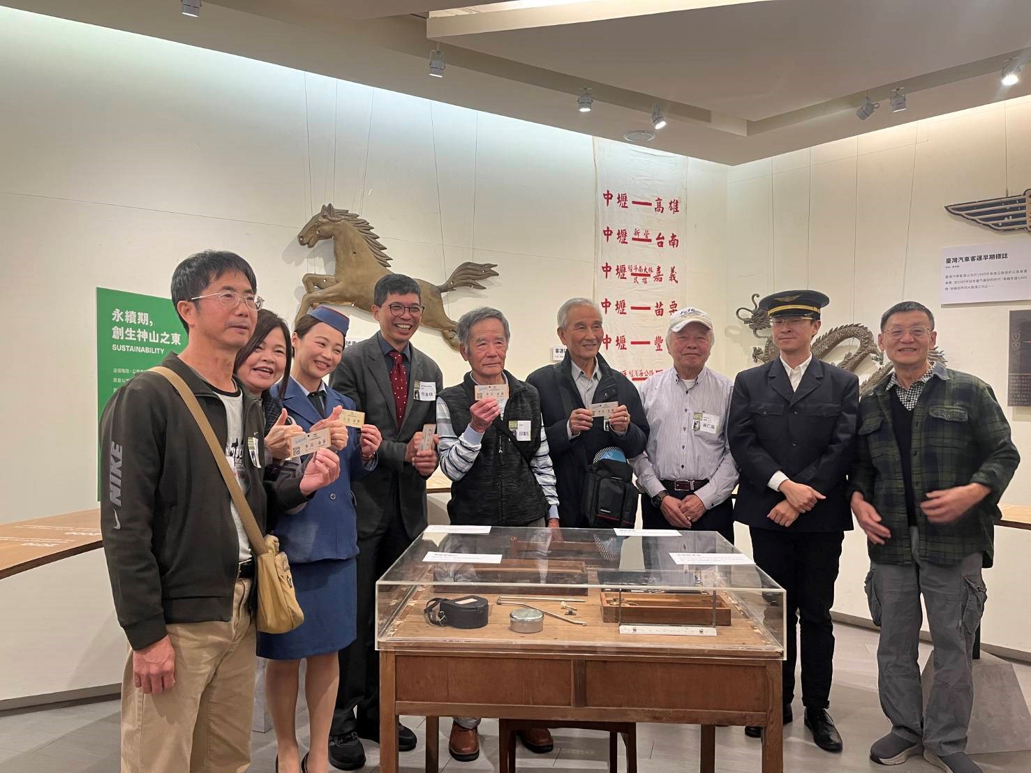 「客隨運轉-幸福公路與客家主題巡展」，參與貴賓手持車票合影【左起邱坤寶、彭歲玲委員、金馬小姐、何金樑主任、邱富松(邱坤寶父親)、劉翼東、葉仁基委員、金馬號司機、徐慶東客籍詩人】