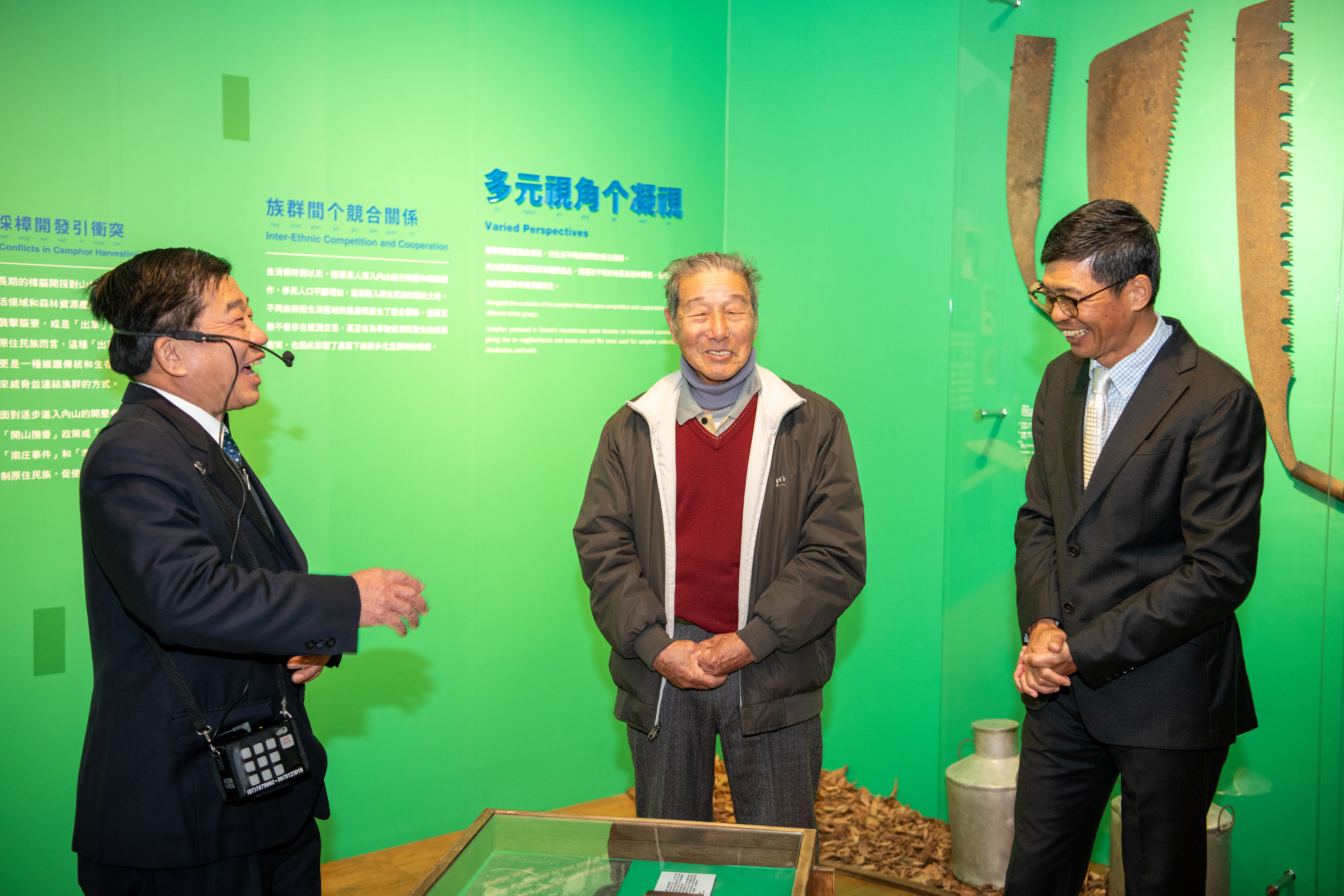 「淺山樟力–臺三線上原客焗腦展」東華樟腦廠第三代傳人吳治增講解腦丁牌原件(左起吳治增先生、吳能達腦長、客發中心何金樑主任)