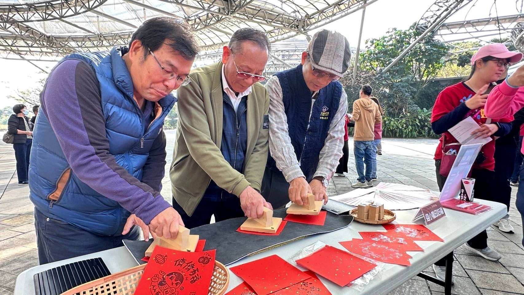 2025六堆新年福 歡喜迎新春，參與貴賓體驗 「迎小龍印好福」蓋印    (左起客家委員會委員黃啟仁、劉仕彩、榮譽顧問邱坤玉)