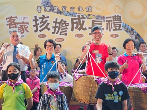 客家成長禮長官貴賓㧡擔傳承給參加學童(左起聯合大學李偉賢校長、苗栗縣政府鄧桂菊副縣長、客發中心何金樑主任、大湖鄉黃惠琴鄉長)